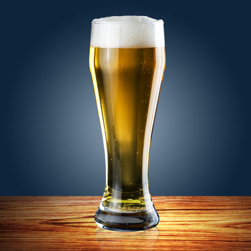 Glass of beer on blue background