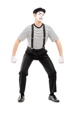 Full length portrait of a young mime artist lifting something im