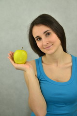 Piękna młoda dziewczyna trzyma zielone jabłko