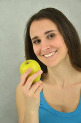 Piękna młoda dziewczyna trzyma zielone jabłko