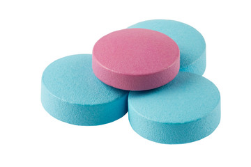 Pink pill on blue pills isolated on white background