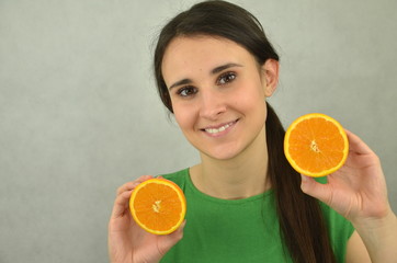 Piękna młoda dziewczyna trzyma pomarańczę