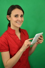 Piękna młoda dziewczyna trzyma biały tablet na zielonym tle