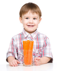Little boy is eating carrot