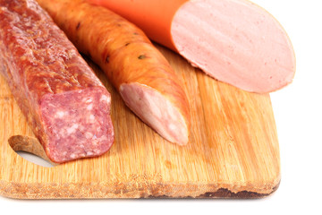 Tasty sausage on chopping board close-up
