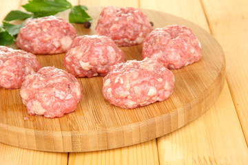 Raw meatballs on wooden table