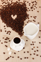 A cup of strong coffee and sweet cream on wooden table close-up