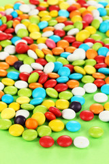 Colorful candies on green background