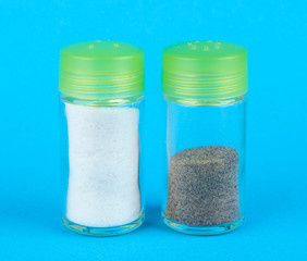 Salt and pepper shakers on color background