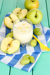 Delicious yogurt in glass with fruit on wooden table close-up