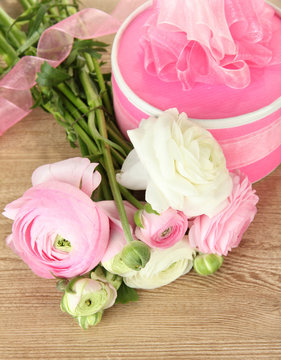 Ranunculus (persian buttercups) and gift on wooden background