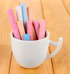 Colorful chalk in cup on table
