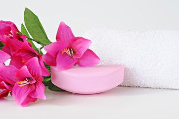 Fototapeta na wymiar Rose soap, towel and flowers on white background