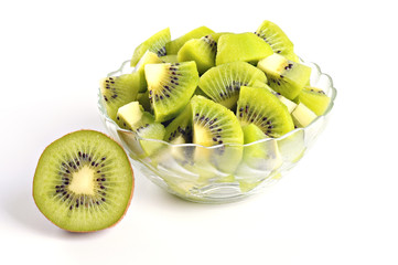 Tasty kiwi pieces in a bowl, half of kiwi, white background