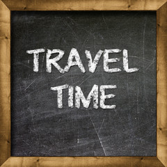 Travel Time handwritten with white chalk on a blackboard.