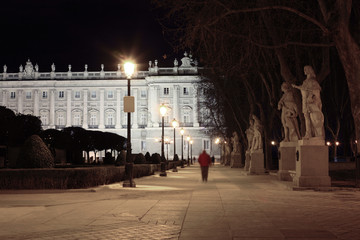 Obraz premium Alley and statues near majestic Royal Palace at night in Madrid,