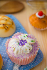 cupcakes muffins with cream fuits , breads, chocolate variety an