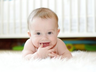 happy baby against white bed