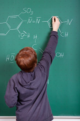 junge schreibt chemische formel an die tafel