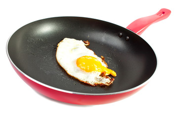 red frying pan with fried egg