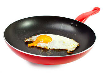 red frying pan with fried egg