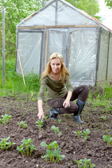 The young woman couch a bed with the first sprouts of potato 