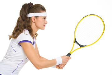 Confident female tennis player in stance. side view