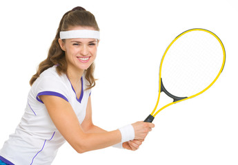 Smiling female tennis player ready to hit ball