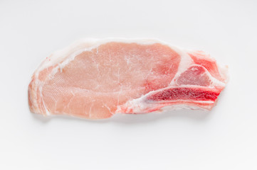 A chop of raw pork on a white background