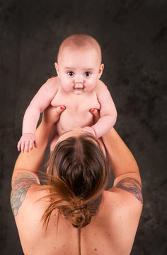 Lovely Mom Holding Her Baby Up With Tattoos