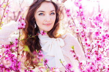 Obraz na płótnie Canvas pretty girl in pink blossom garden
