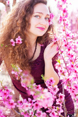 Naklejka premium pretty girl in pink blossom garden