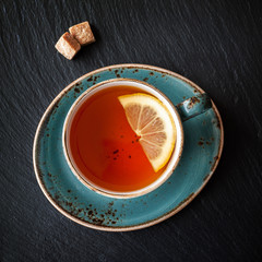 Tea with lemon on black slate board