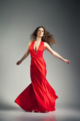 Naklejka premium Ballet dancer wearing red dress over grey