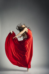 Ballet dancer wearing red dress over grey