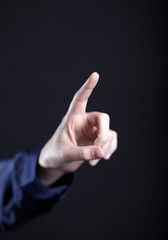 Female hand with finger on dark background