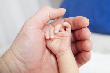 holding a hand of the newborn child