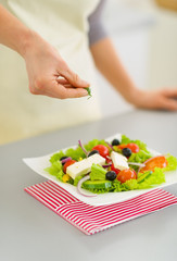 Obraz na płótnie Canvas Closeup on woman adding fresh dill into salad