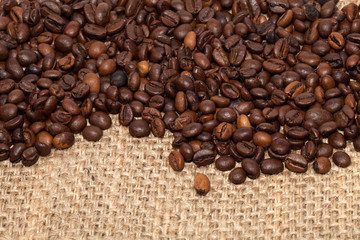 Coffee grains on rough fabric of linen close-up