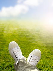 Sneakers in the grass with grass and sky background