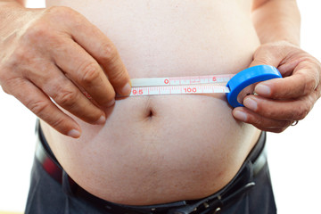 腹囲を測定する肥満気味の男性