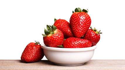 Strawberries in white plate on the wooden board. Isolated