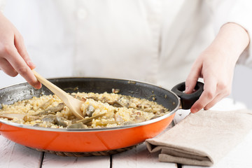 Cook mixing a ready to serve vegetables rice pan