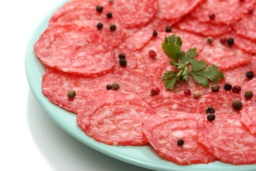 tasty sausage with spices on plate, isolated on white