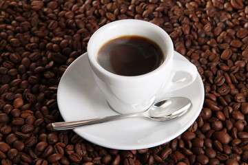 Cup of coffee on coffee beans background