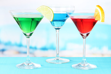 Glasses of cocktails on table near pool