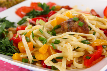 Noodles with vegetables on plate close-up