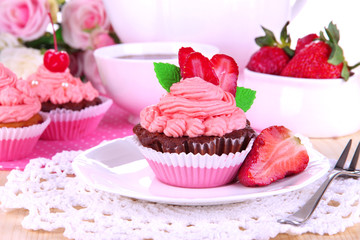 Beautiful strawberry cupcakes on dining table close-up
