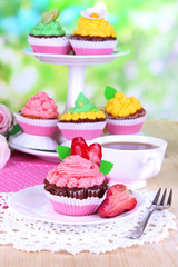 Beautiful cupcakes on dining table on natural background