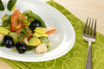 Tasty avocado salad in bowl  on wooden table close-up